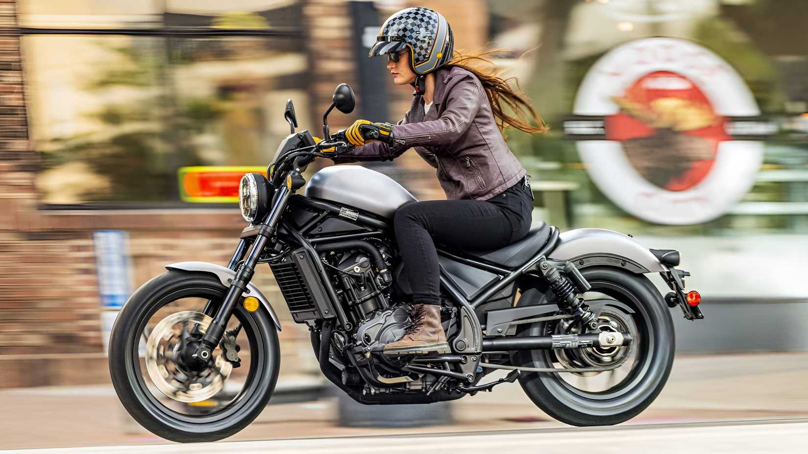 2026 Honda Rebel 1100 acelerando pelas estradas da cidade, vista de perfil do terceiro trimestre