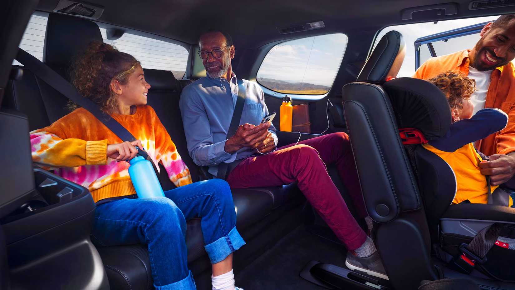 Uma família carregando um Toyota Grand Highlander Hybrid 2026
