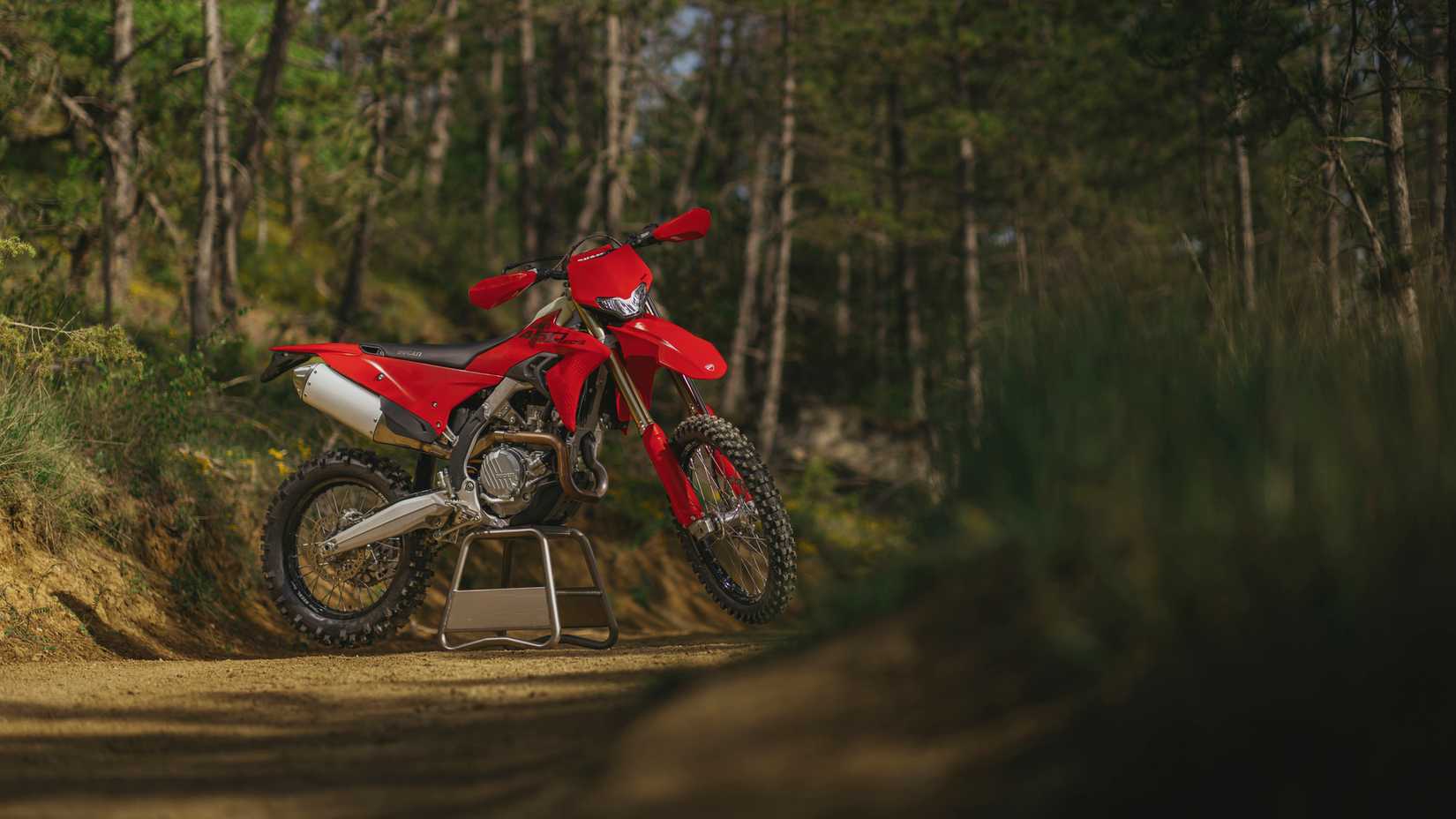 2027 Ducati Desmo450 EDS estacionada em uma trilha