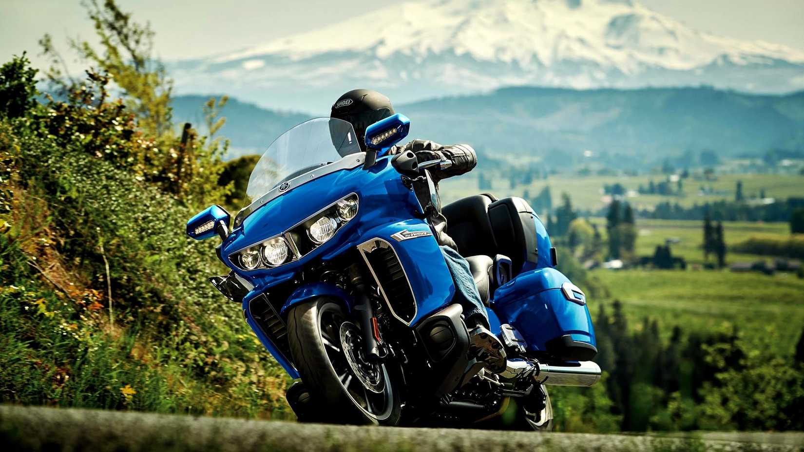 Blue Yamaha Star Venture curvando em frente a uma montanha