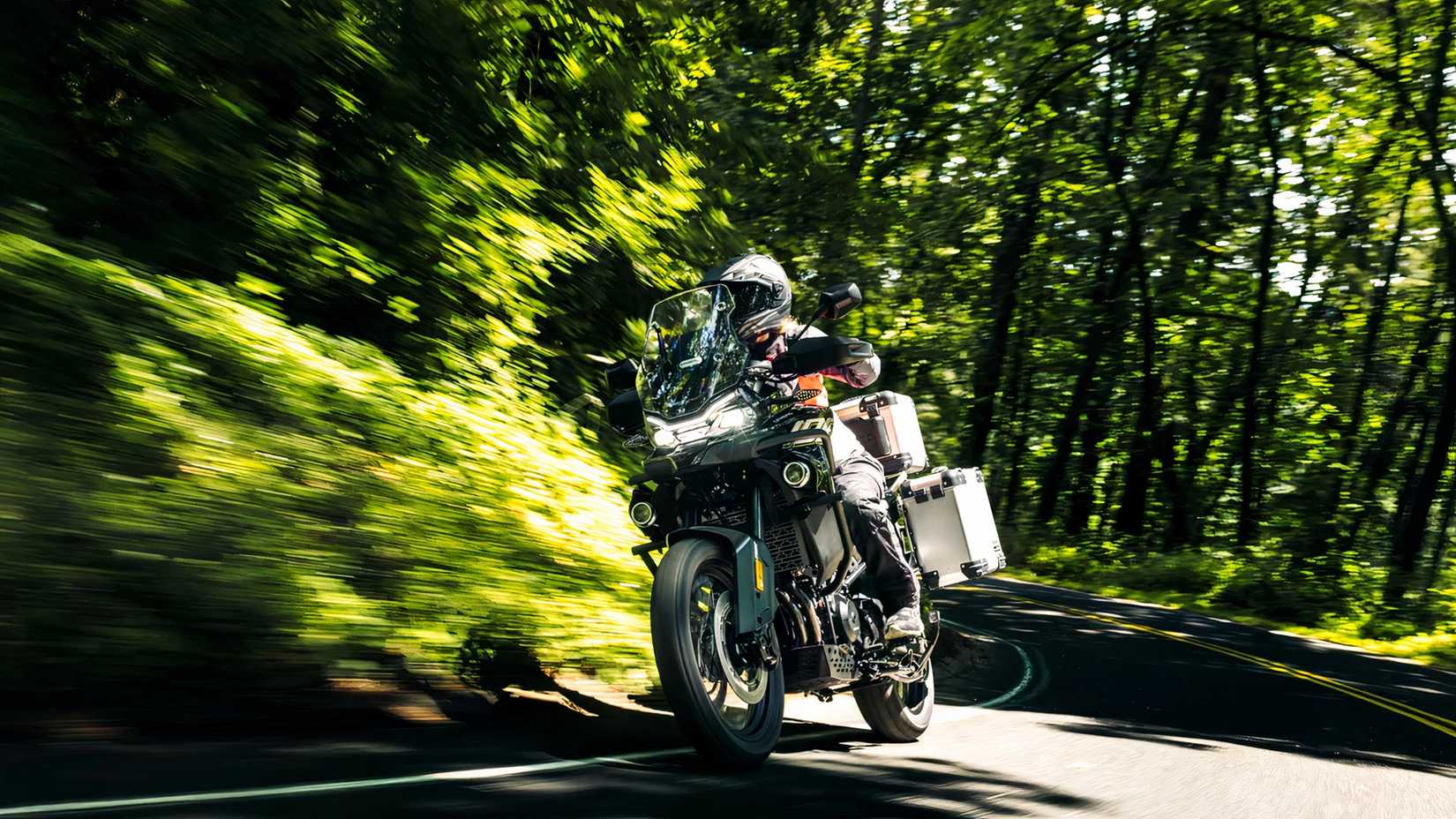 CFMoto Ibex 800 E passing through a road with trees in the background