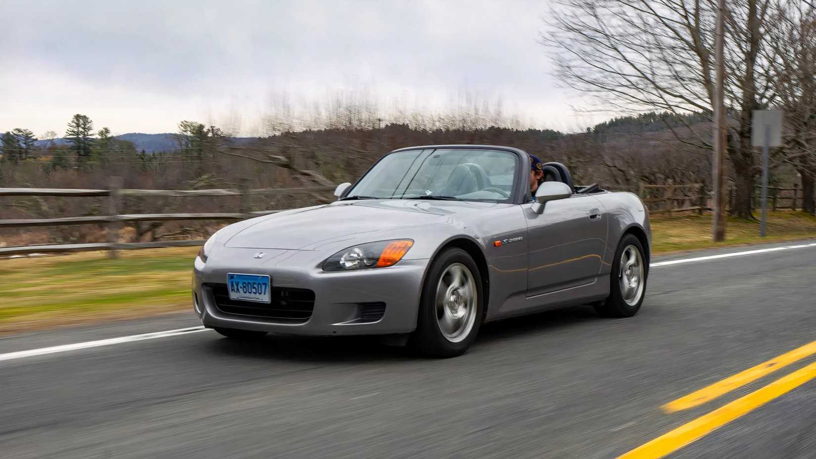 Foto frontal de ação 3/4 de um Honda S2000 2000 dirigindo na estrada