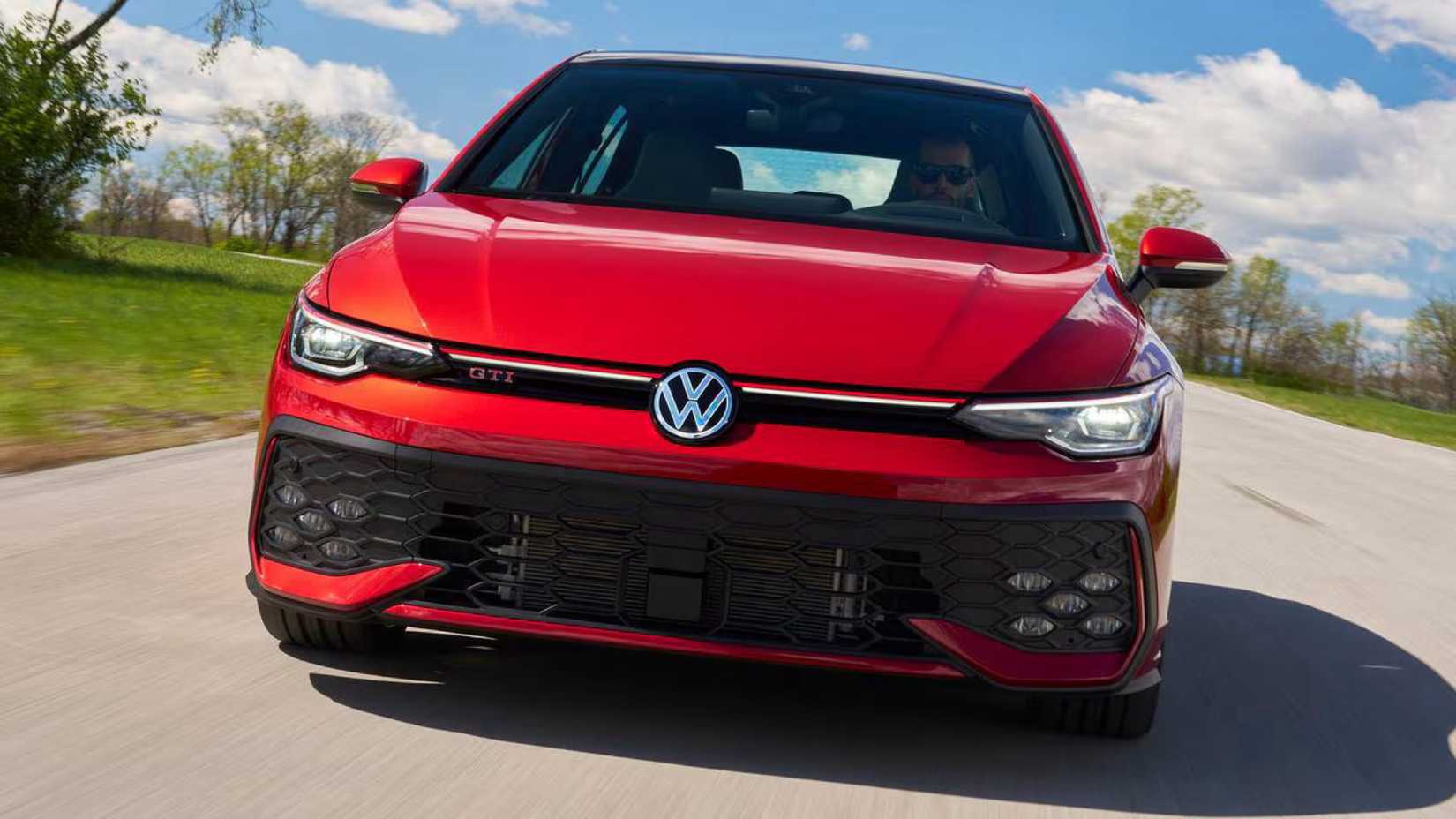 Front action shot of 2026 Volkswagen Golf GTI driving on road