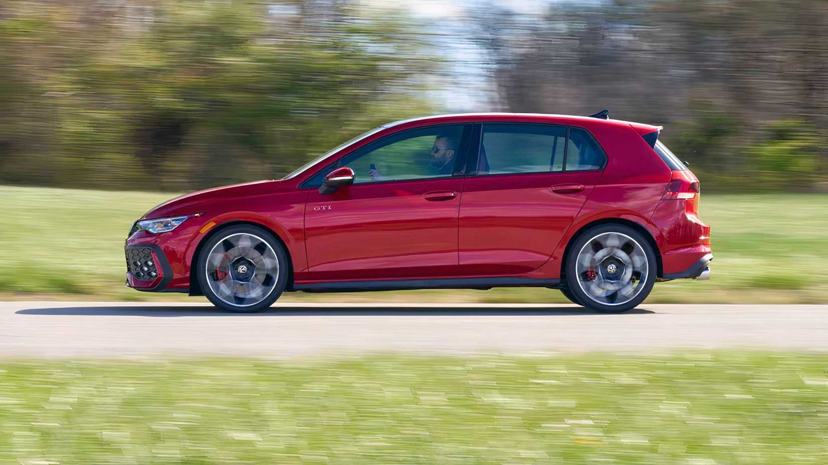 Profile action shot of 2026 Volkswagen Golf GTI driving on road