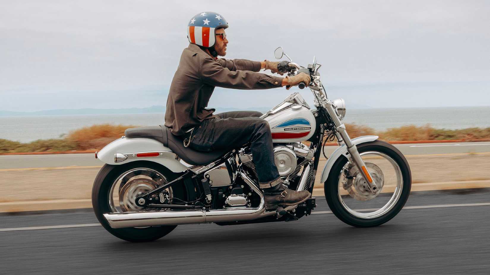Foto panorâmica da Harley-Davidson Super Glide 2026 andando na estrada do lado direito