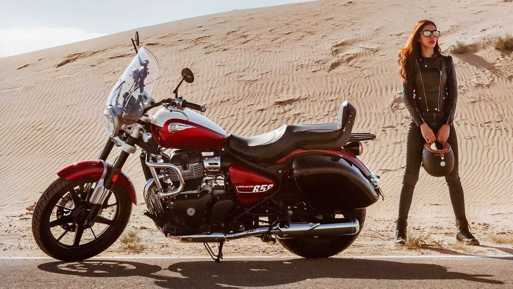 Foto estática de beleza de uma Royal Enfield Super Meteor 650 junto com uma piloto feminina
