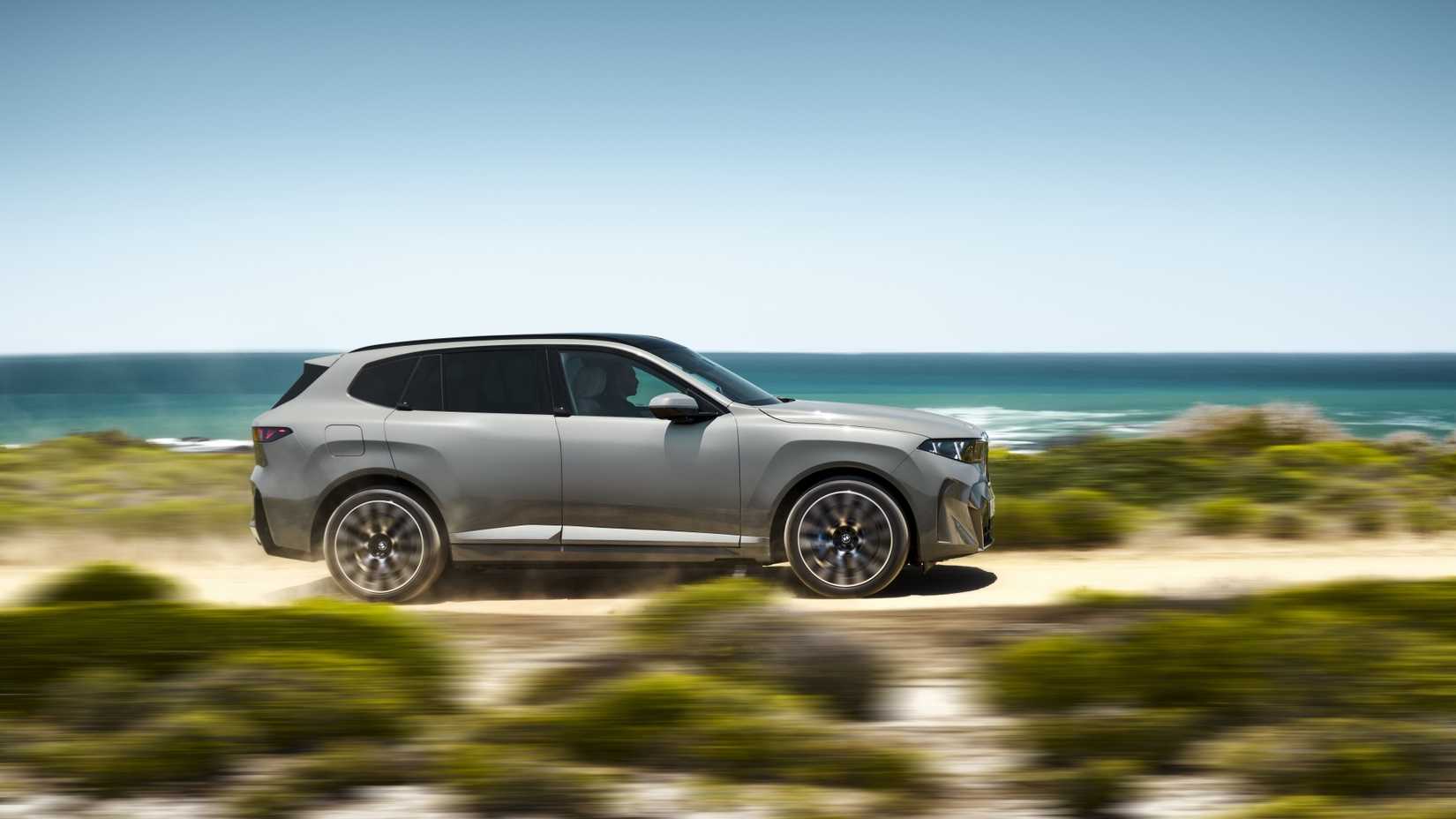 2027 BMW iX5 60 xDrive tiro lateral dirigindo