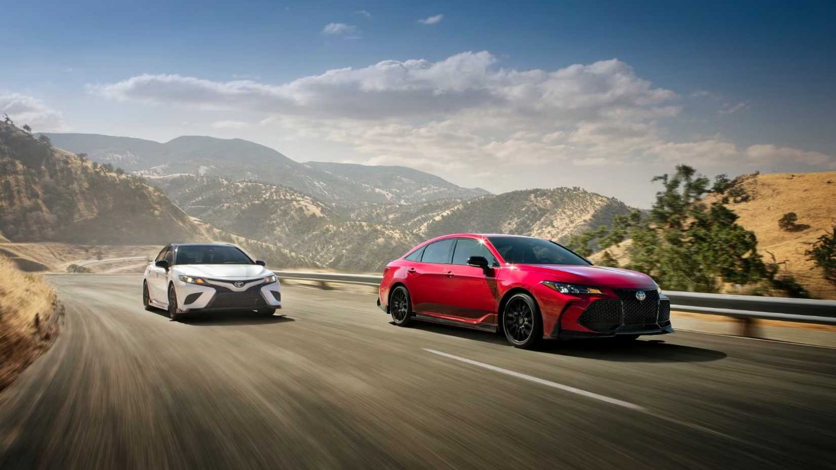 Foto frontal de um Toyota Avalon TRD 2022 dirigindo pela estrada ao lado de um Camry TRD