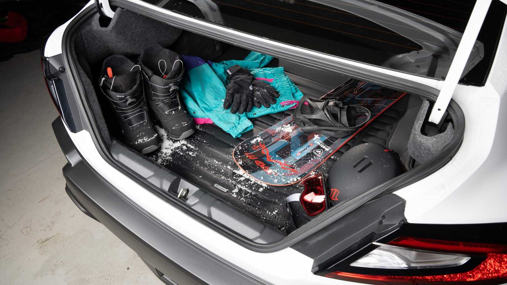 A wide shot of the trunk of the Subaru WRX with the Tuxmat and some snow tools.