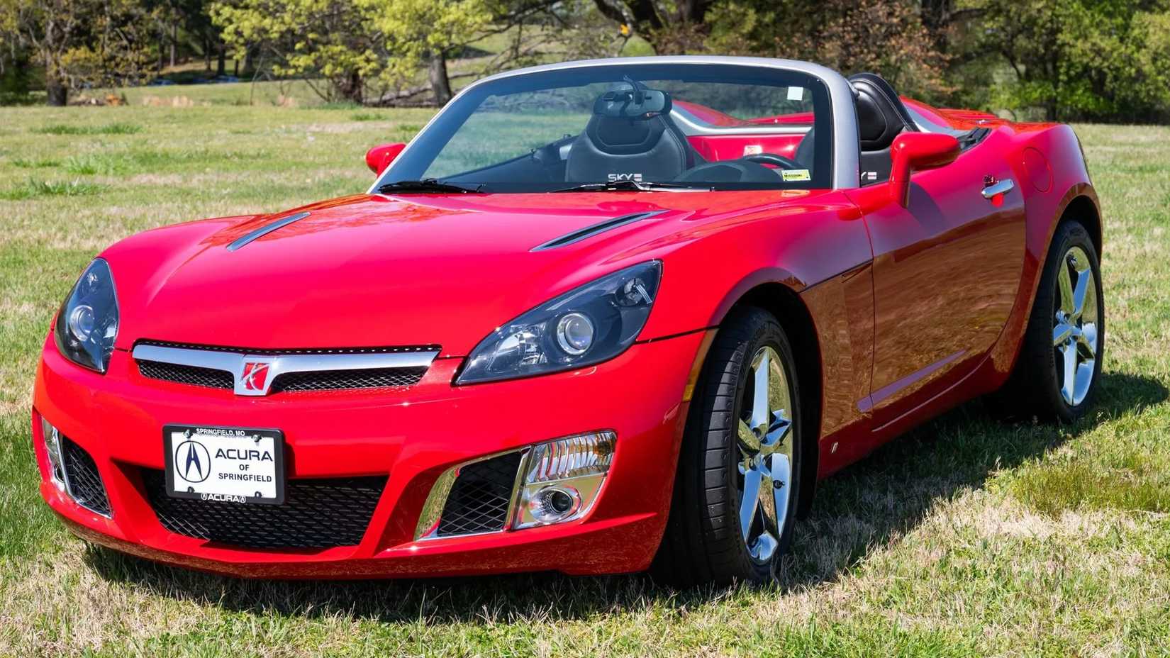 Red 2008 Saturn Sky Red Line frontal 3/4 tiro estacionado na grama