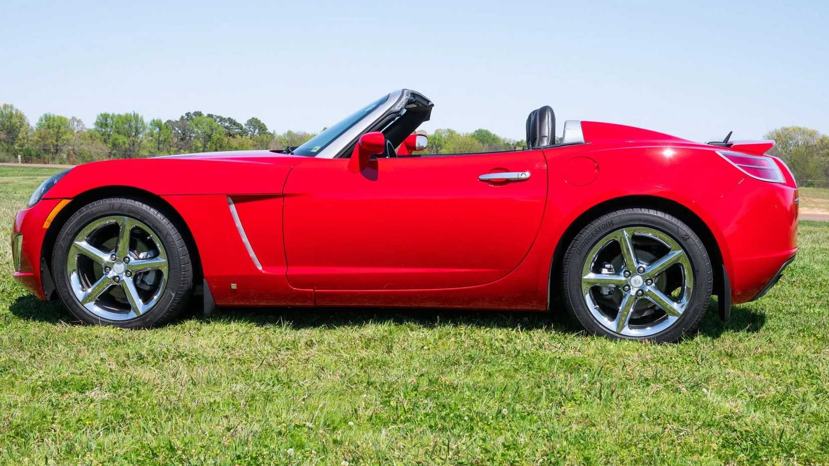 Red 2008 Saturn Sky Red Line tiro lateral estacionado na grama
