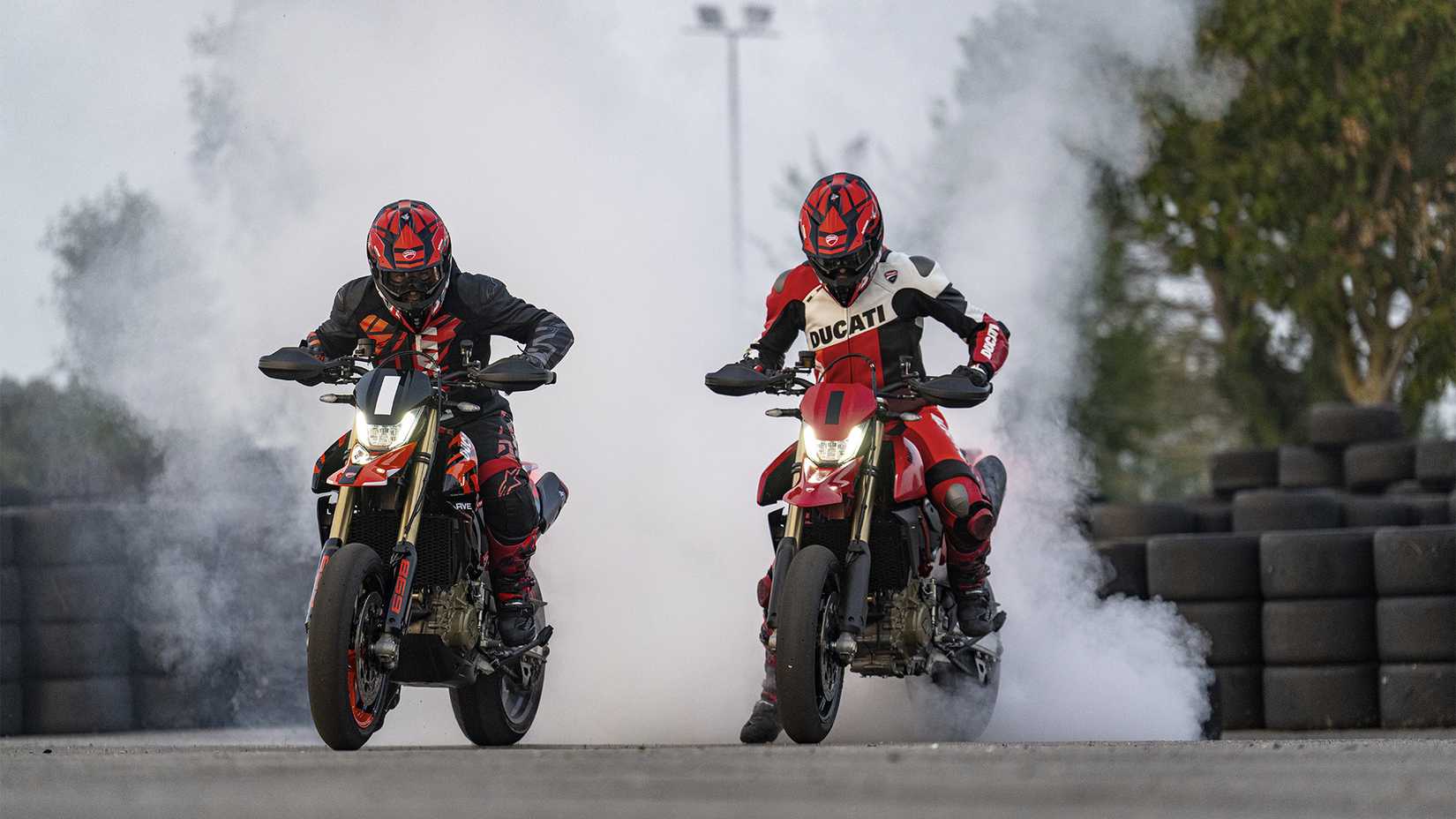Uma foto de ação de duas Ducati Hypermotard 698 queimando