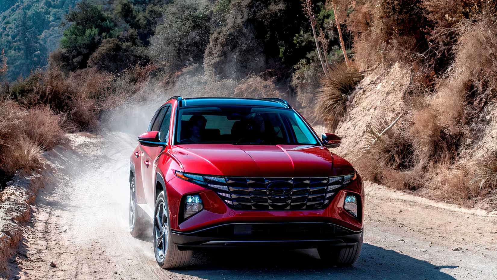 Front 3/4 action shot of 2023 Hyundai Tucson Hybrid driving on dirt road