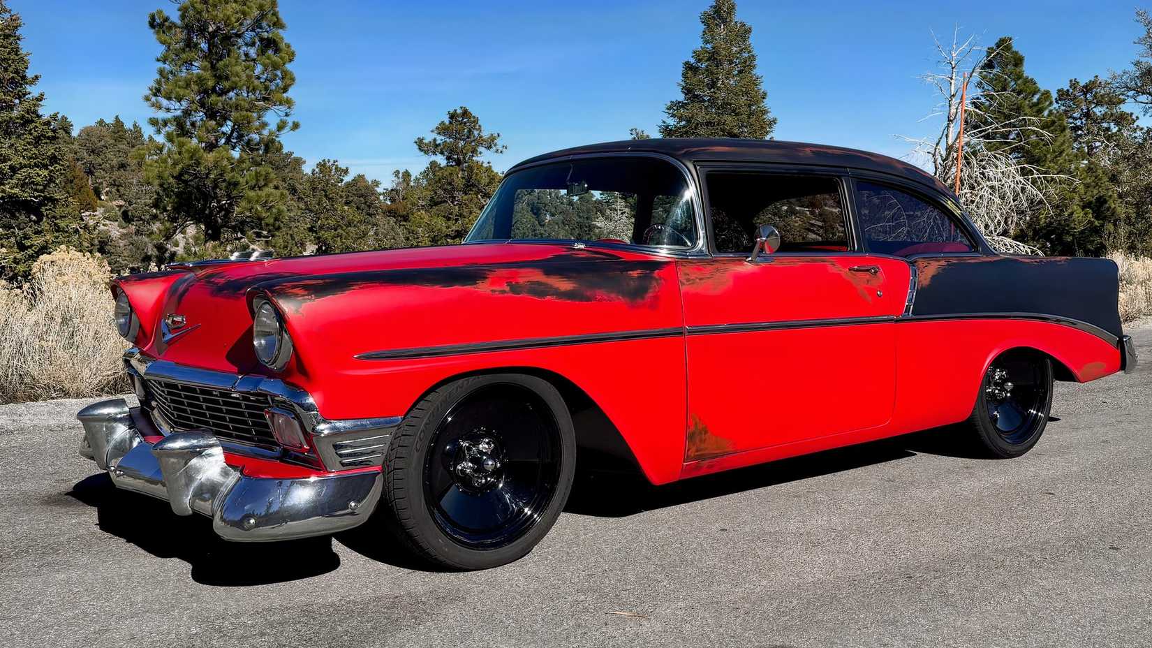 A red and black restored 1956 Chevy 210 Tri-Five