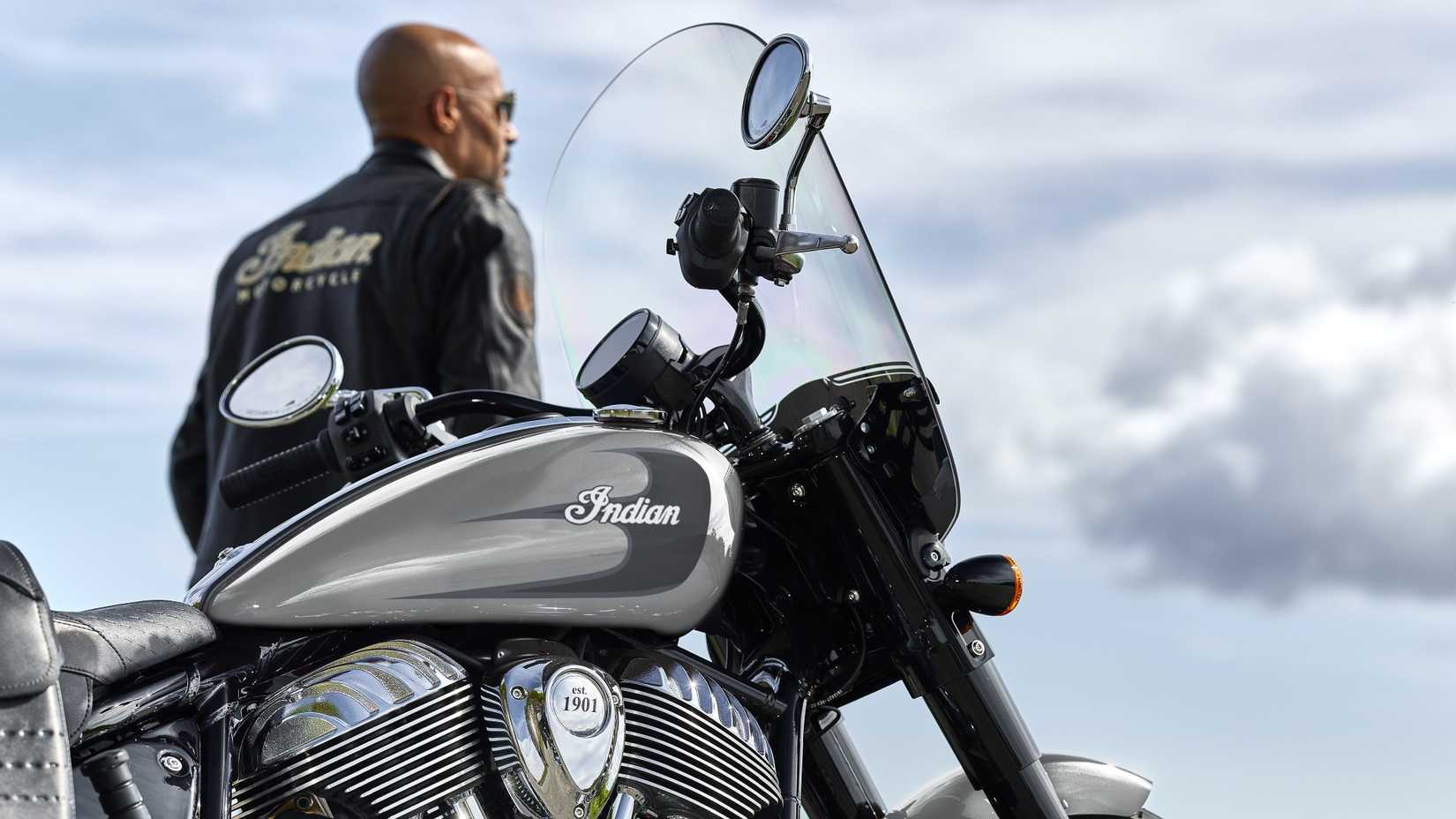 Um piloto parado ao lado de um close-up cinematográfico do Indian Super Chief 2026 estacionado