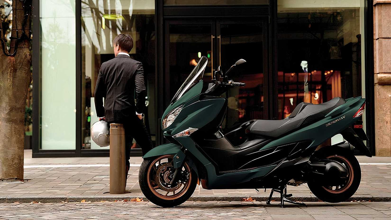 Suzuki Burgman 400 estacionada em frente a uma loja com o piloto esperando ao lado