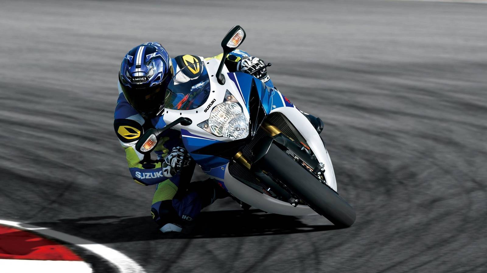 Una moto sportiva Suzuki GSX-R750 in corsa, con colori vivaci e design aerodinamico, su fondo stradale