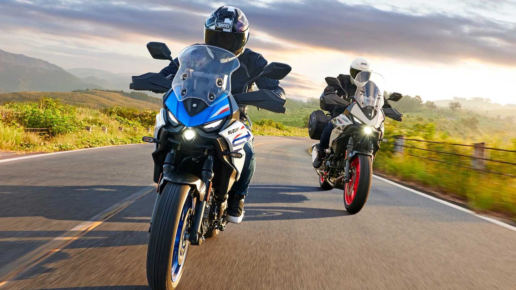 Action shot of two 2027 Suzuki SV-7GX models on a mountain road, front view