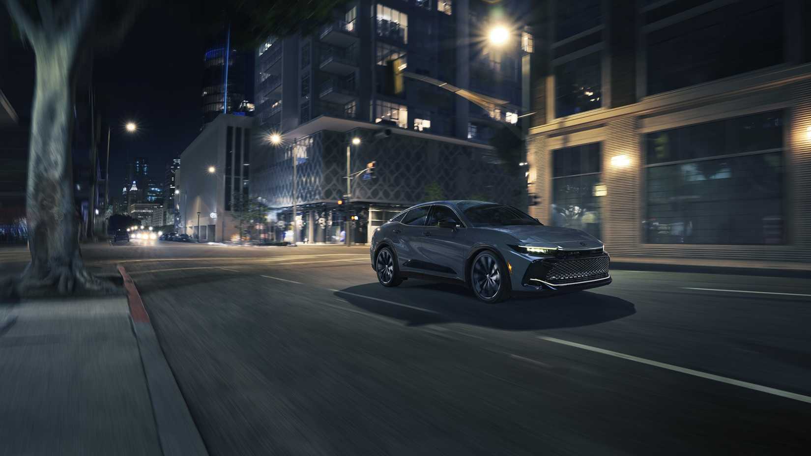 Foto frontal do Toyota Crown 2027 dirigindo pela cidade à noite