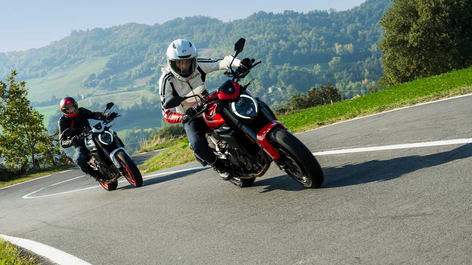 Two Ducati Monsters cornering on a mountain road