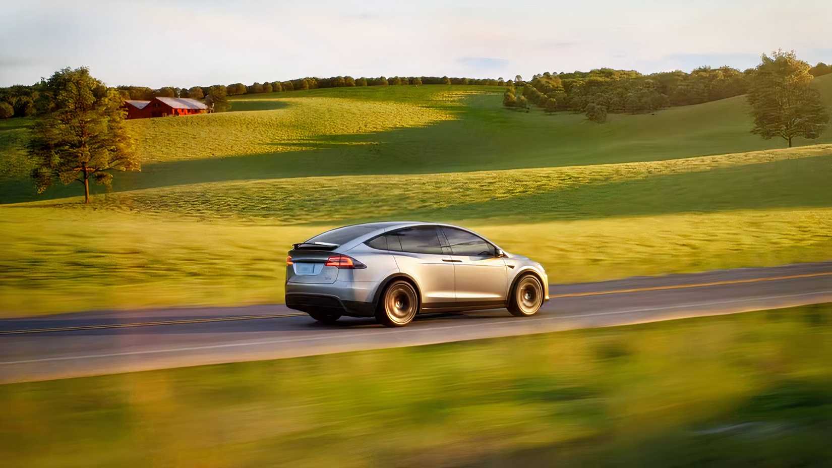 Rear 3/4 action shot of 2026 Tesla Model X driving on road