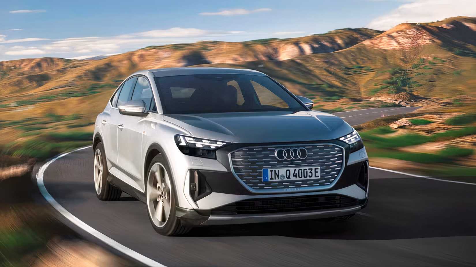 Front 3/4 action shot of 2026 Audi Q4 Sportback e-tron driving on road