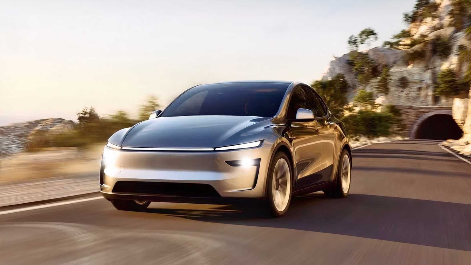 Front 3/4 action shot of 2026 Tesla Model Y front 3/4 action driving on road