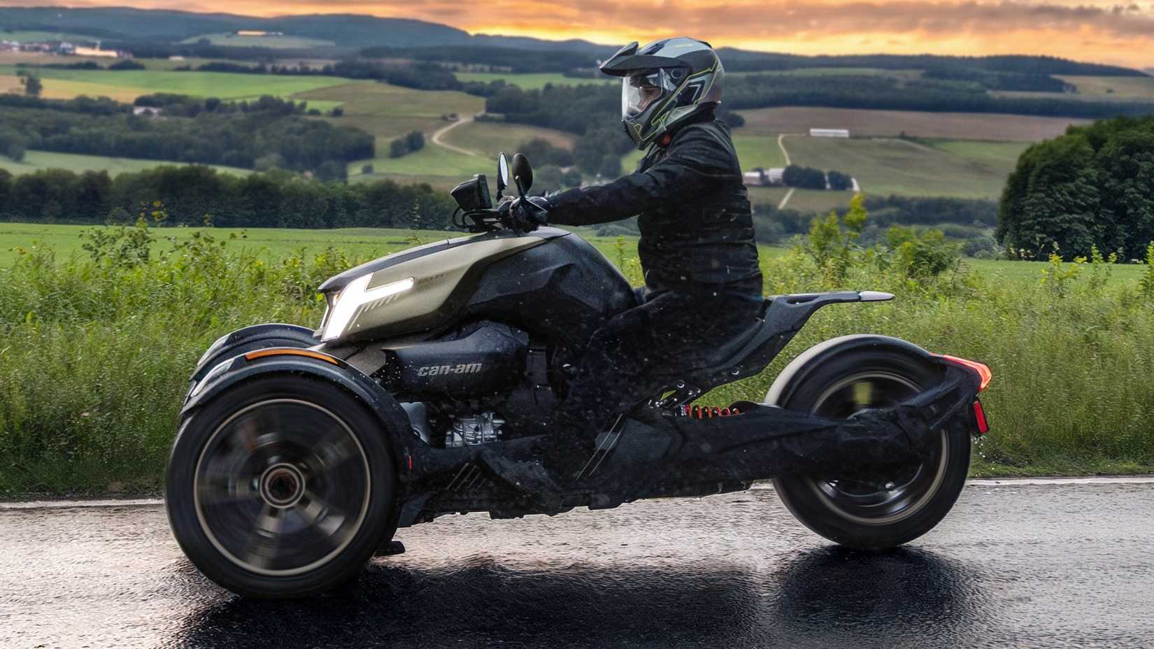 Can-Am Ryker Sport cruising on a scenic mountain road side profile view