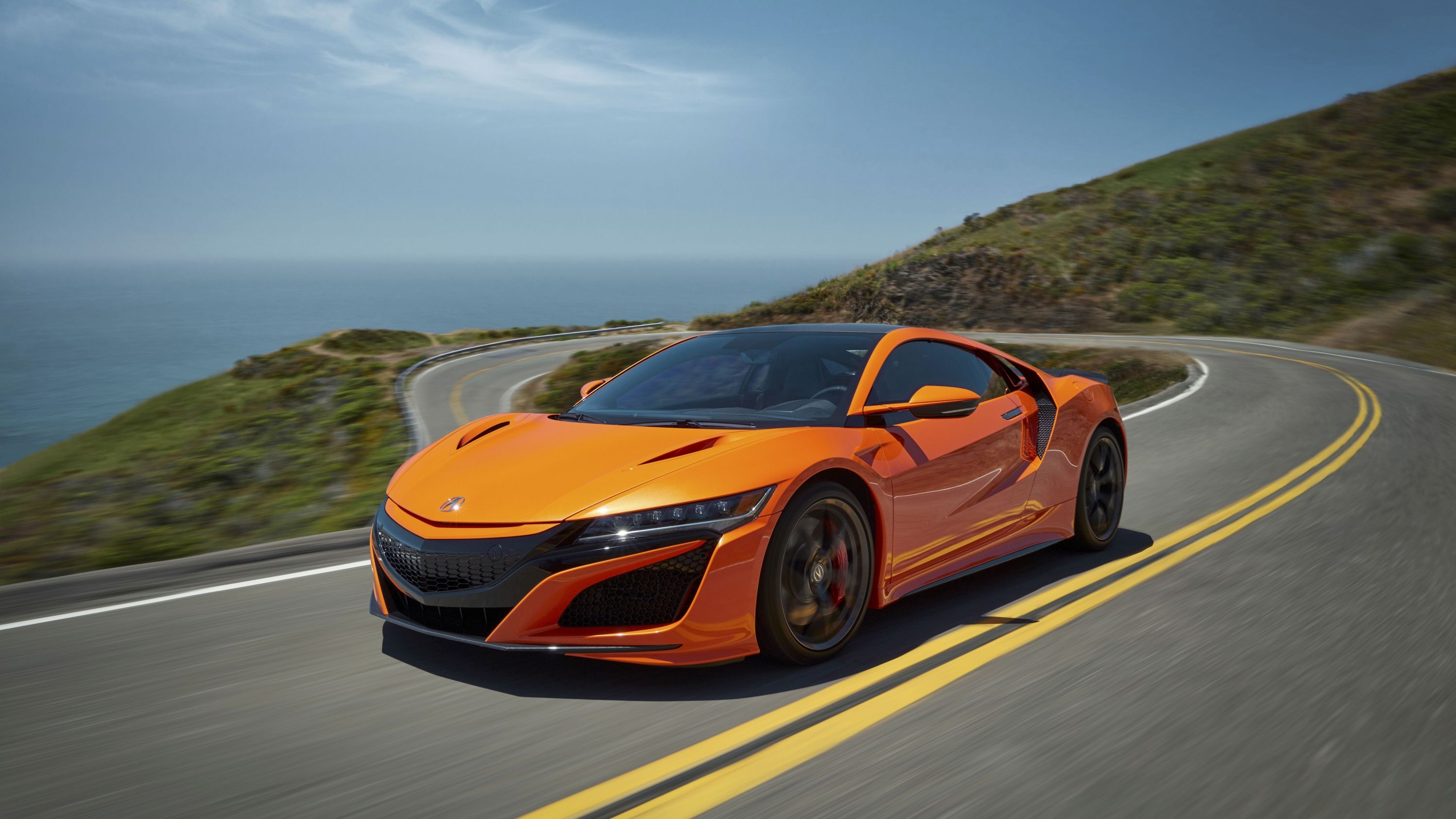 Orange 2019 Acura NSX driving along a highway