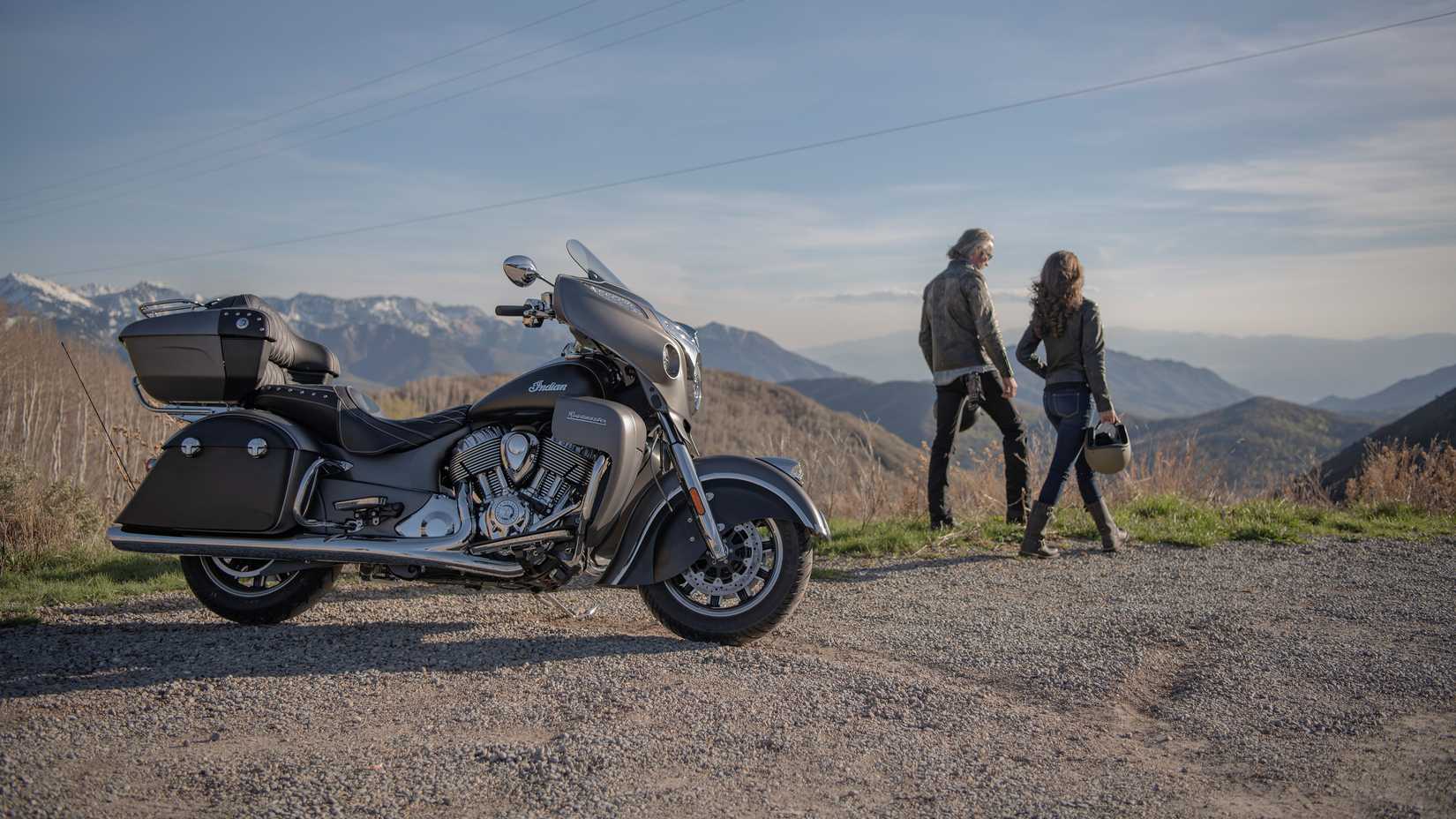 2016-2019 Indian Roadmaster estacionado em um estacionamento com vista para um vale com o piloto e o passageiro parados na beira