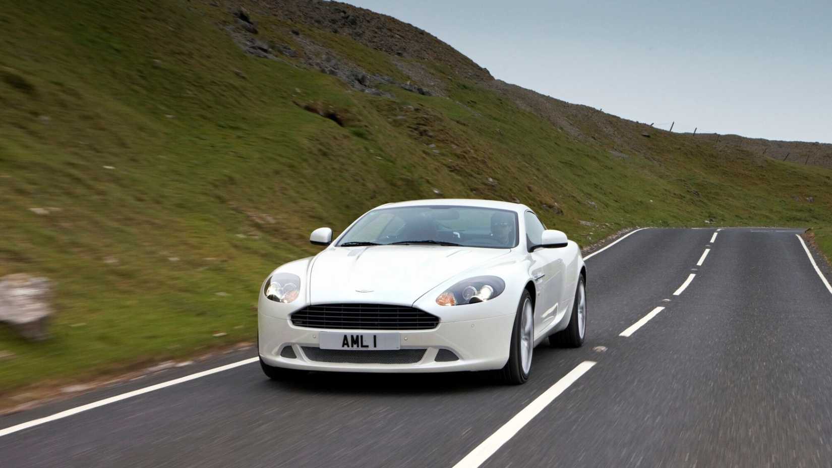 A front angle shot of a 2005-2012 Aston Martin DB9 Coupe driving