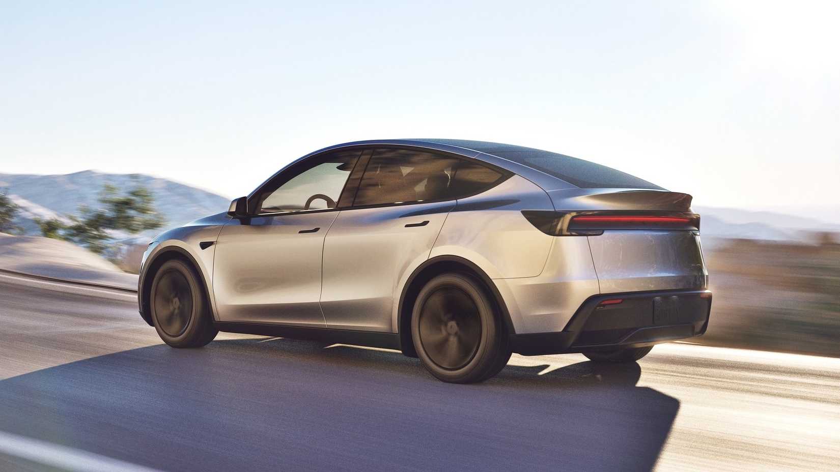 2025 Tesla Model Y rear 3/4 shot driving on the road