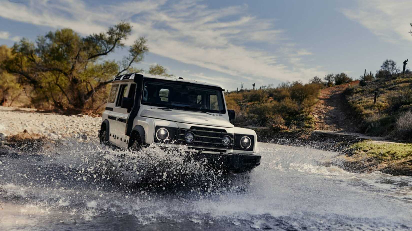 2024 Ineos Grenadier driving through river front 3/4