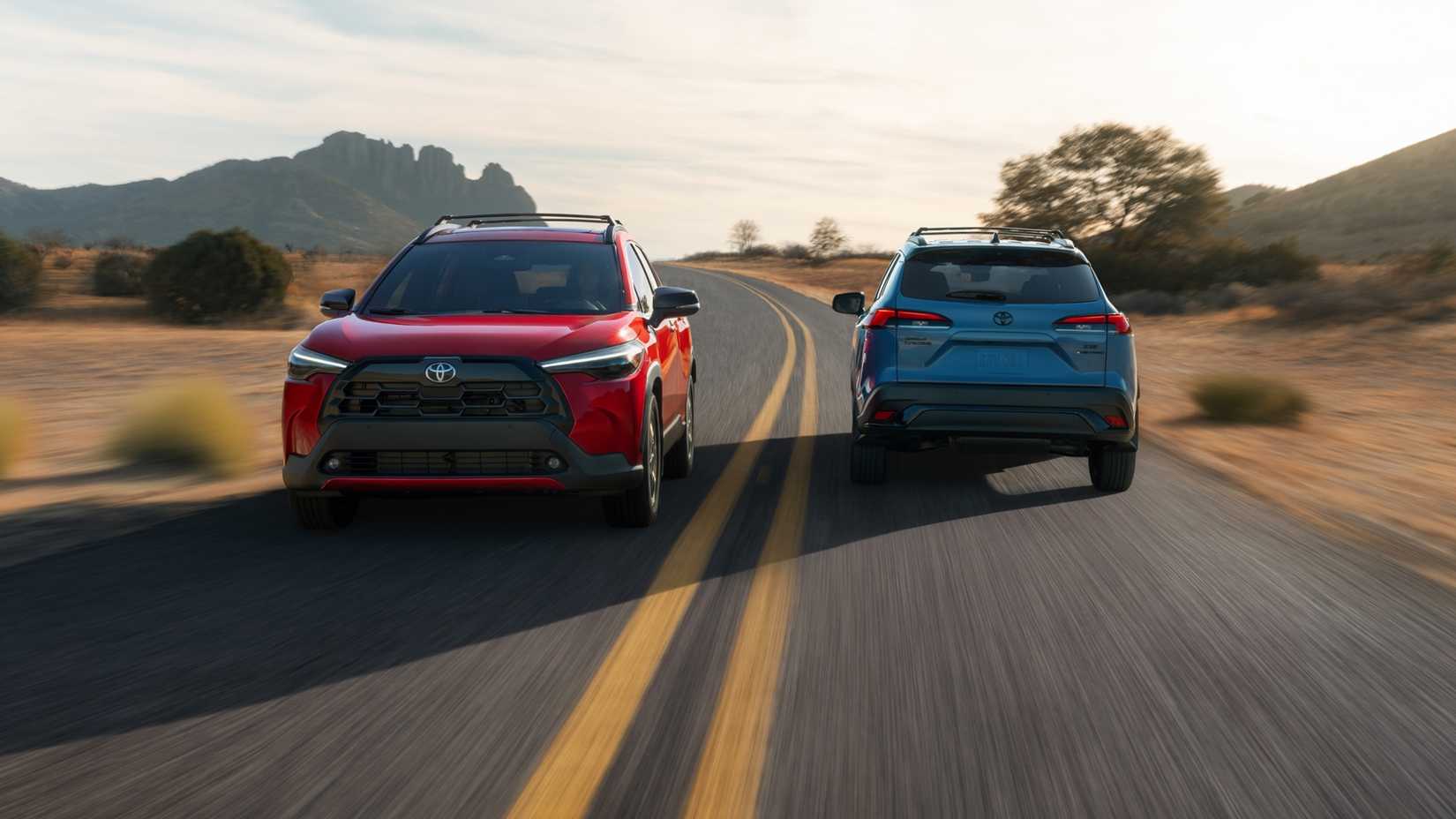 Toyota Corolla Cross in red acelerating besides a blue