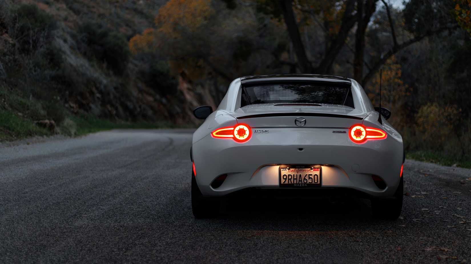 Rear action shot of 2026 Mazda MX-5 Miata RF driving on road