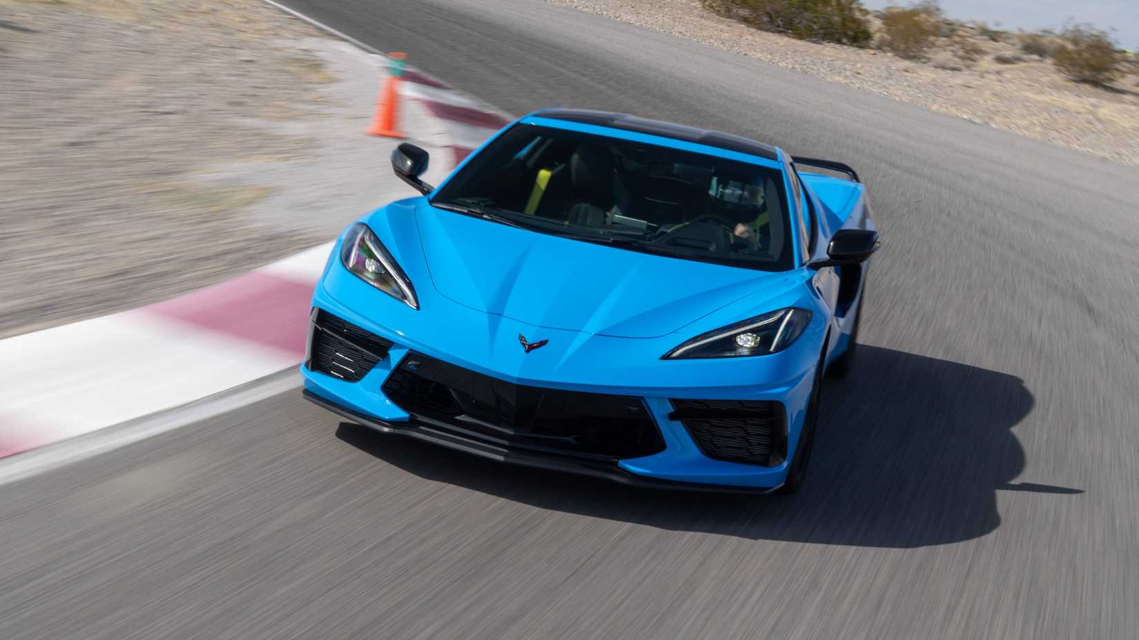 Um Chevrolet Corvette Stingray 2026 azul dirigindo em uma esquina em uma pista de corrida