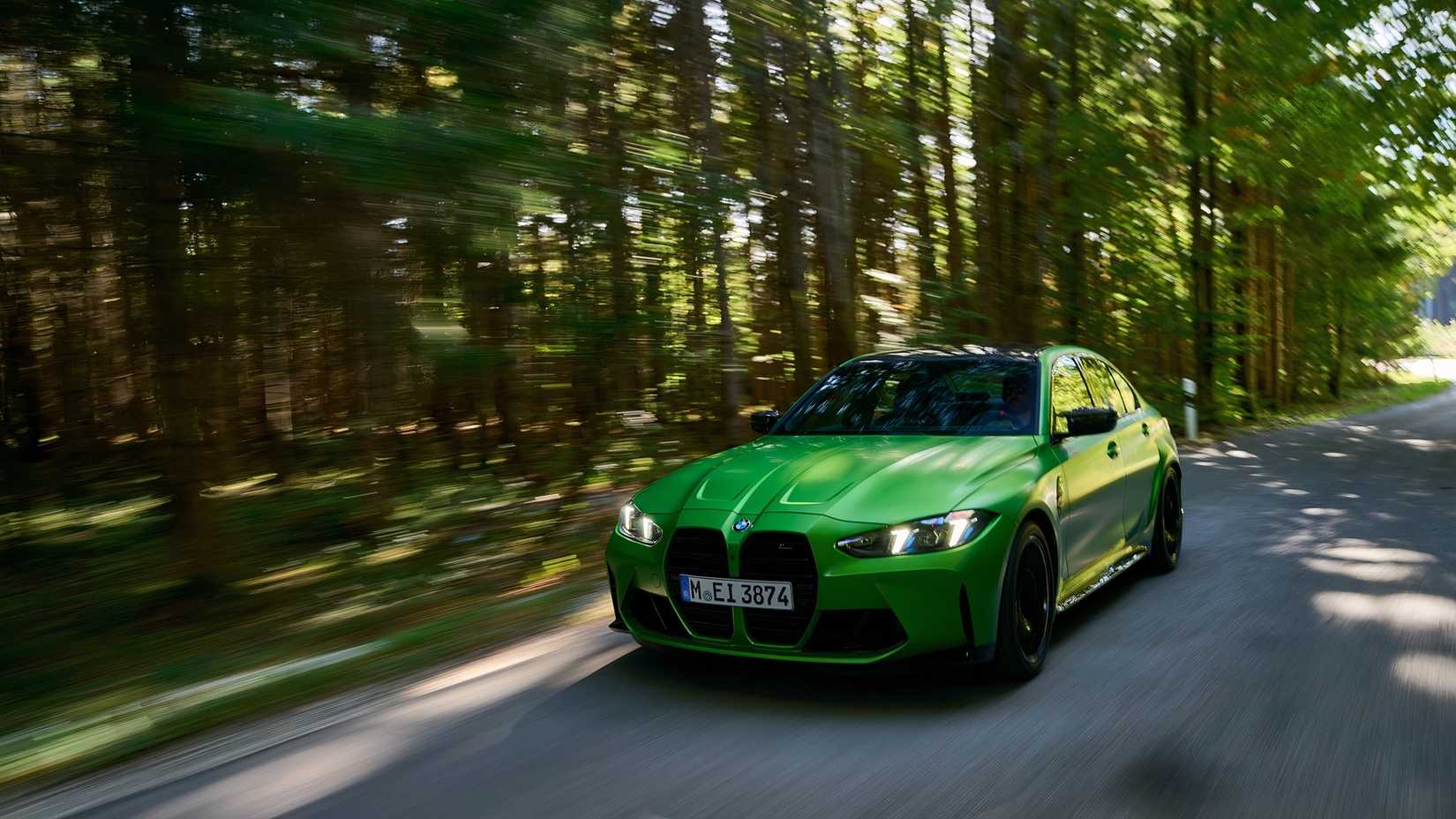 Front 3/4 action shot of 2026 BMW M3 driving on road