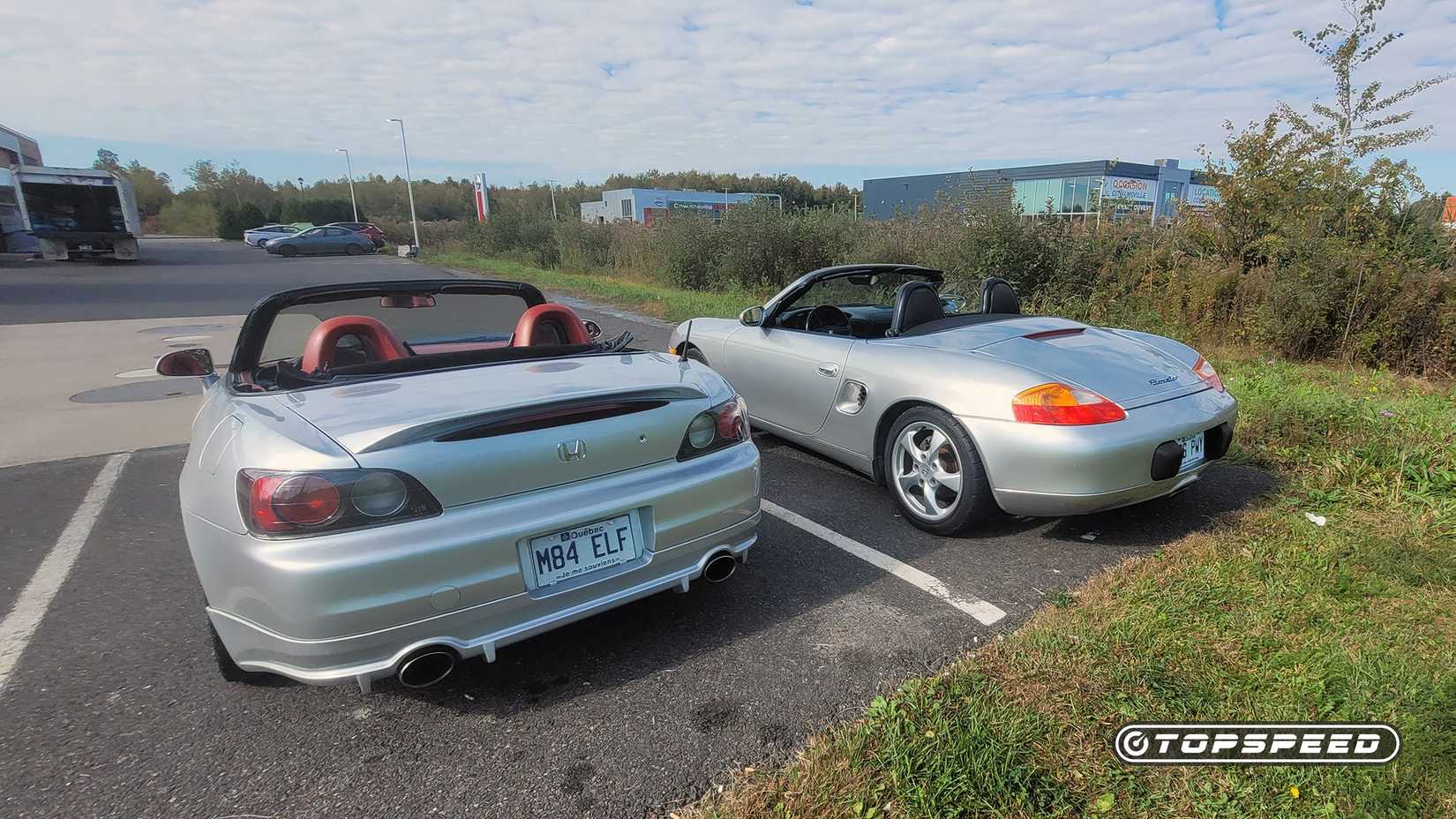 Rear shot of a 2001 Porsche Boxster and Honda S2000 parked side by side
