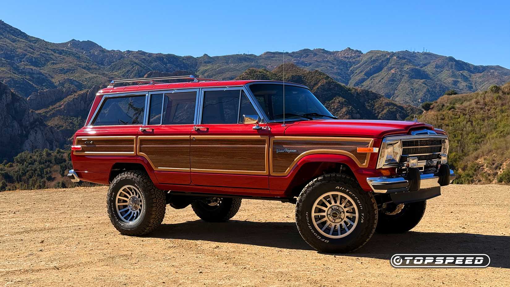 Foto lateral de um Vigilante Hellcat Redeye Grand Wagoneer vermelho 1988 estacionado fora da estrada