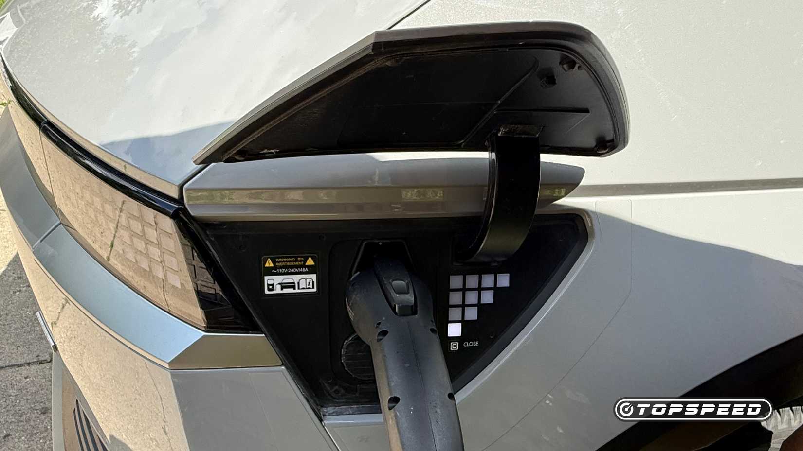 The charging port of a gray 2022 Hyundai Ioniq 5 SE with plug