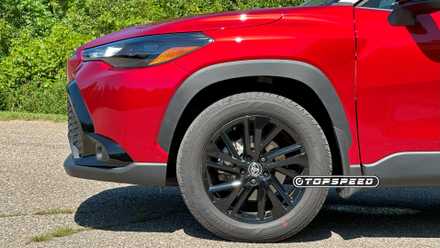 Front-end close-up of a red 2025 Toyota Corolla Cross Hybrid Nightshade's wheel