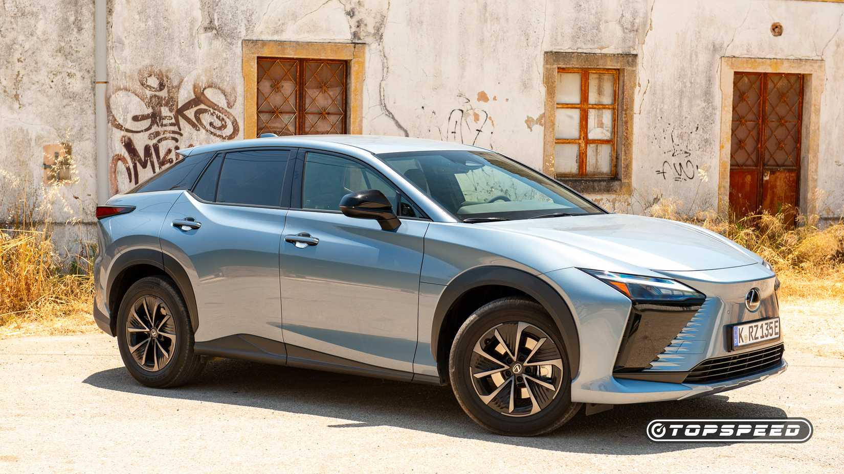 2026 Lexus RZ 350e frente 3/4 tiro estacionado em estrada de terra