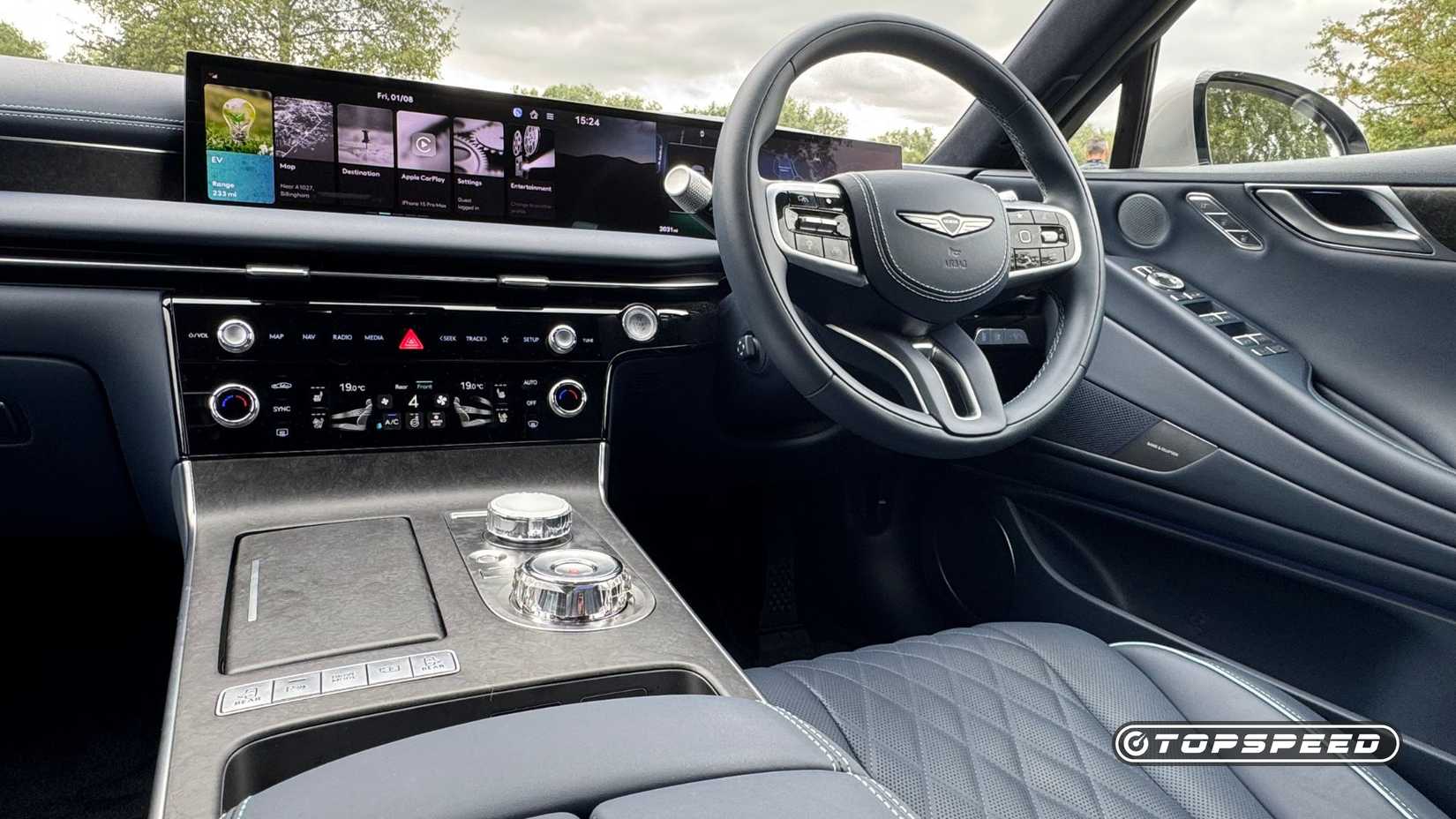 Close-up shot of the steering wheel, infotainment screen, and center console in the 2026 Genesis Electrified G80.