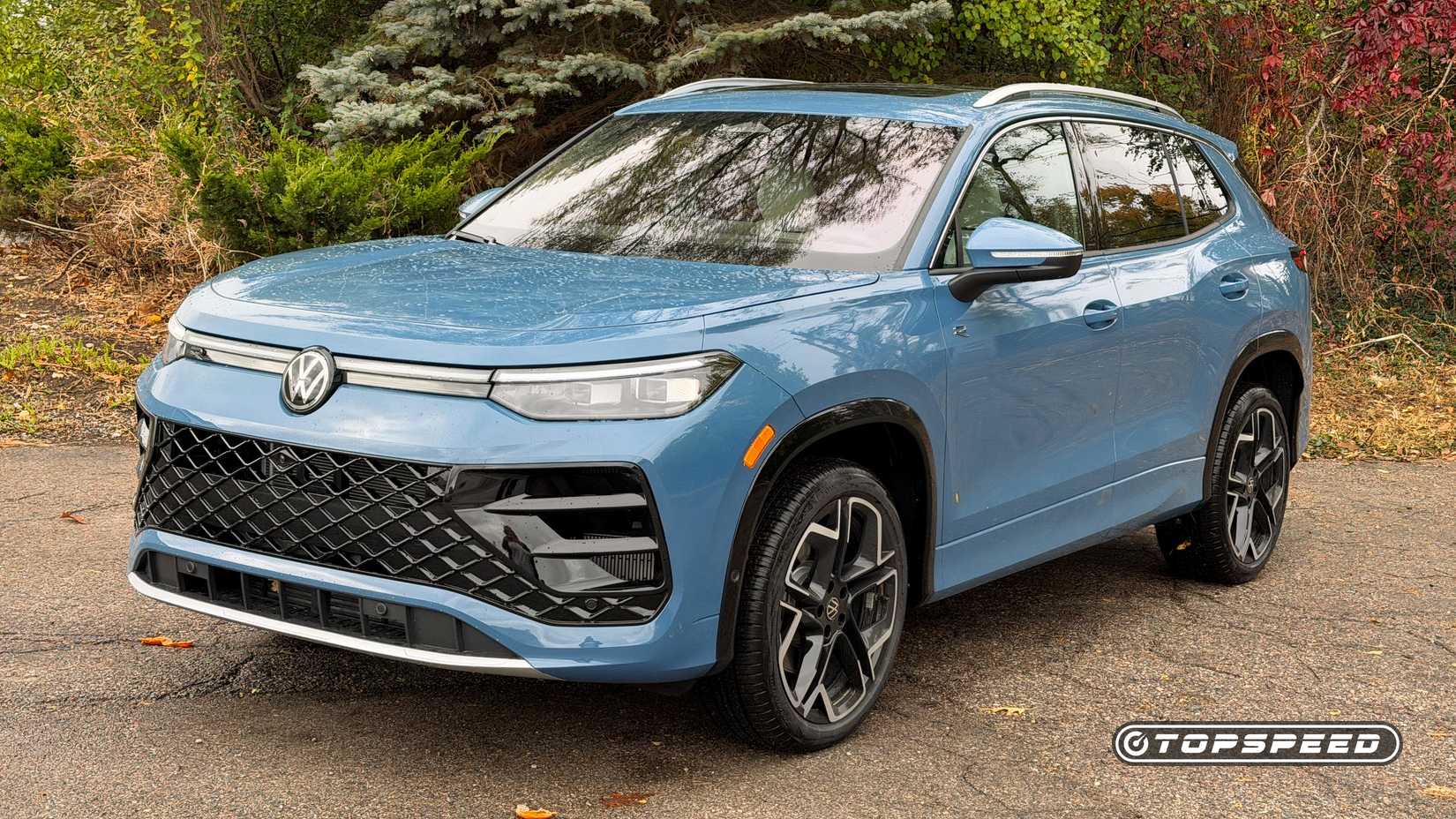 Foto frontal 3/4 de um Volkswagen Tiguan 2026 azul estacionado na estrada