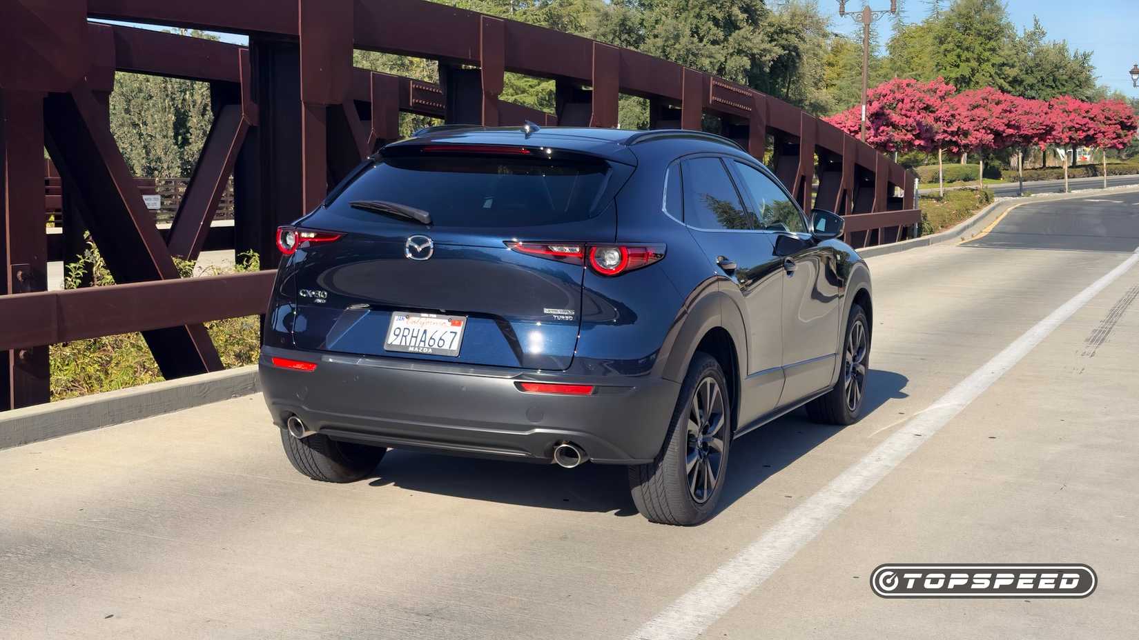 Rear 3/4 shot of a 2025 Mazda CX-30 2.5 Turbo Premium Plus Exterior driving over a bridge